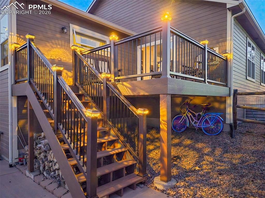 View of property exterior featuring stairway and a deck