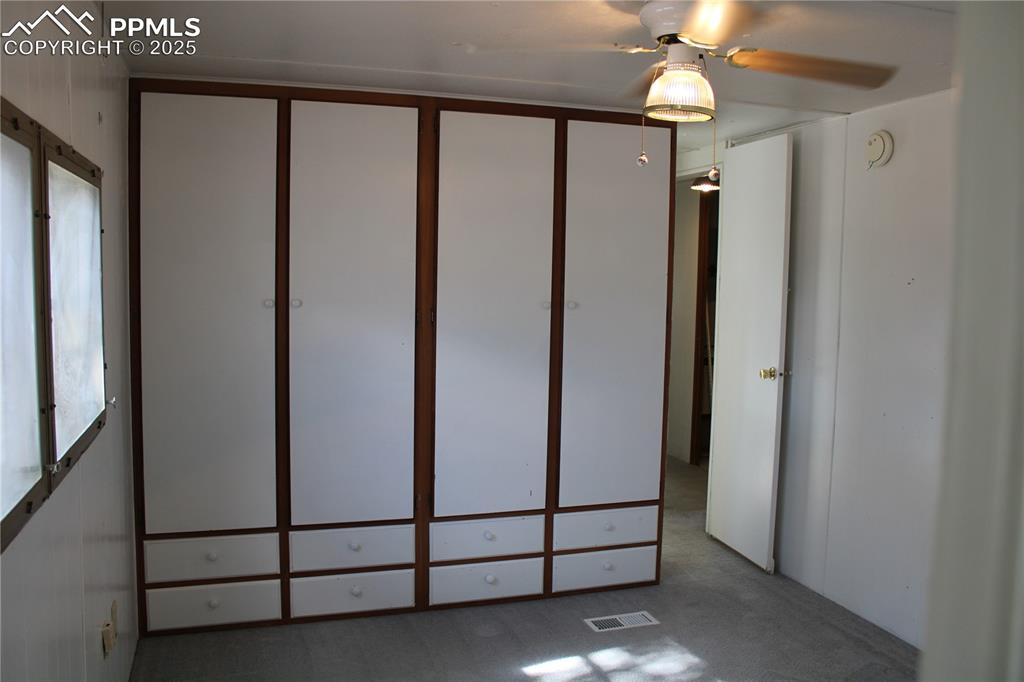 Unfurnished bedroom with carpet flooring and ceiling fan
