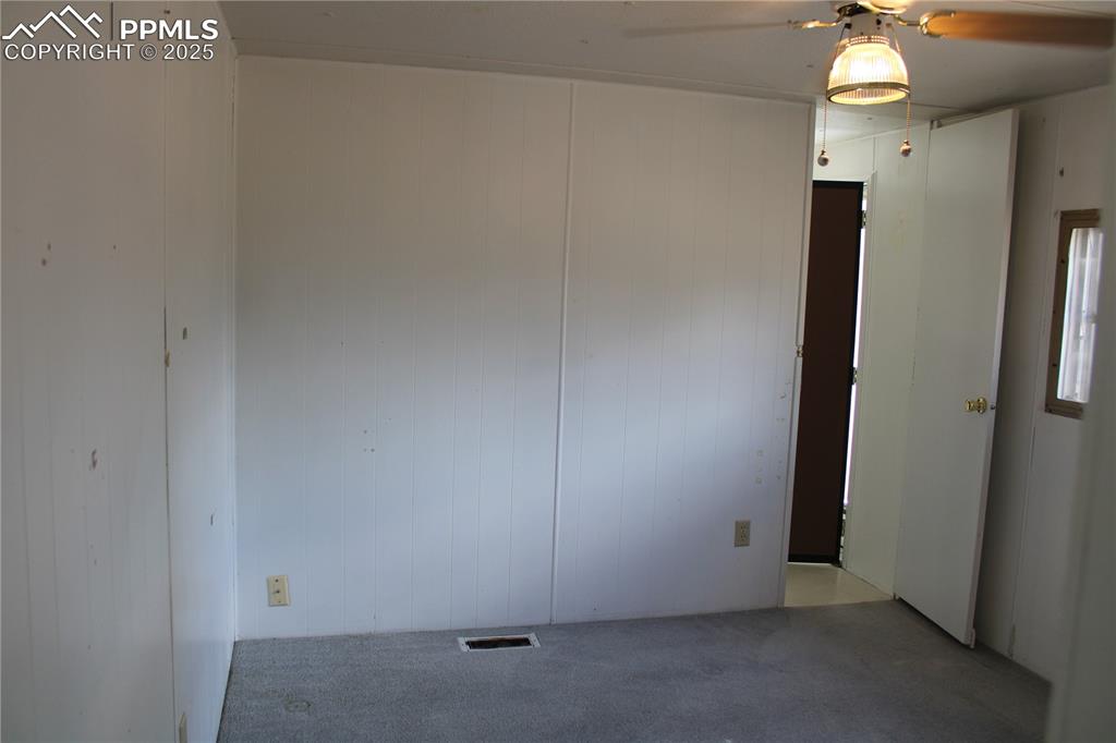 Carpeted spare room with wooden walls