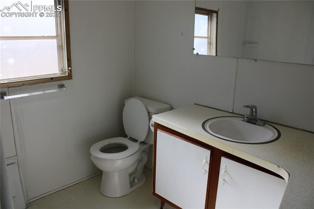 Half bath featuring vanity and light flooring