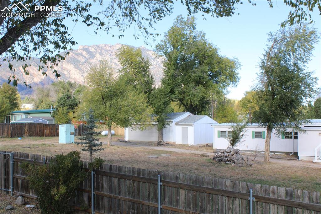 View of front of house featuring a mountain view and a fenced backyard
