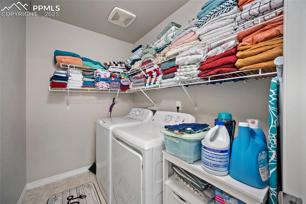 Laundry room with light tile patterned flooring and washing machine and dryer