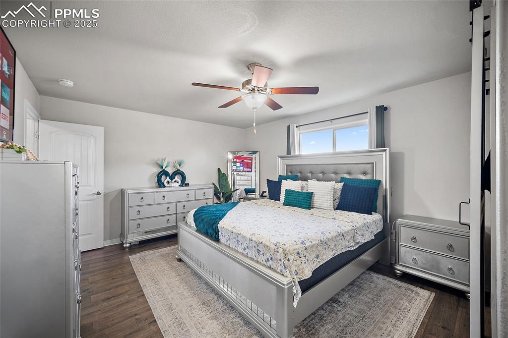 Bedroom featuring dark wood-style flooring and ceiling fan