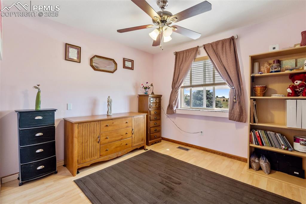 Secondary upper level bedroom with natural light and wood floors
