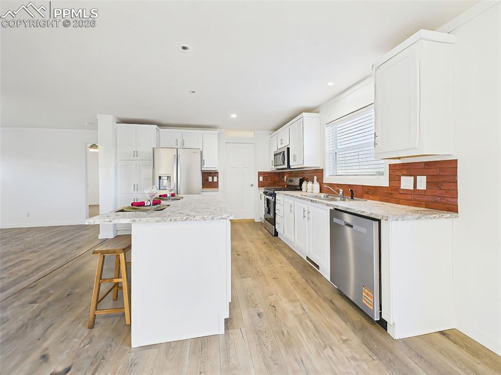 Stretching along the side wall, this kitchen offers generous counter space, contemporary tile backsplash, and easy flow for cooking and entertaining.