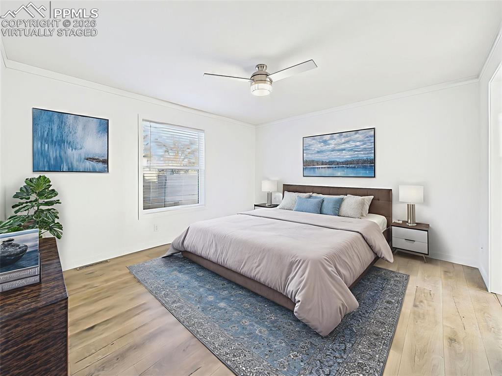 Virtually Staged A bright and airy primary suite with large window, ceiling fan, and ample space for a king bed and additional furniture.