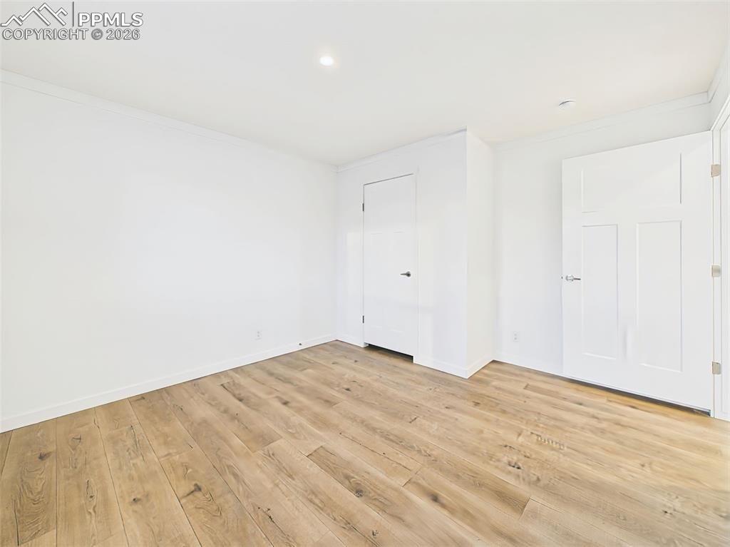 Blank canvas bedroom 2 with wood-look flooring and generous closet space.