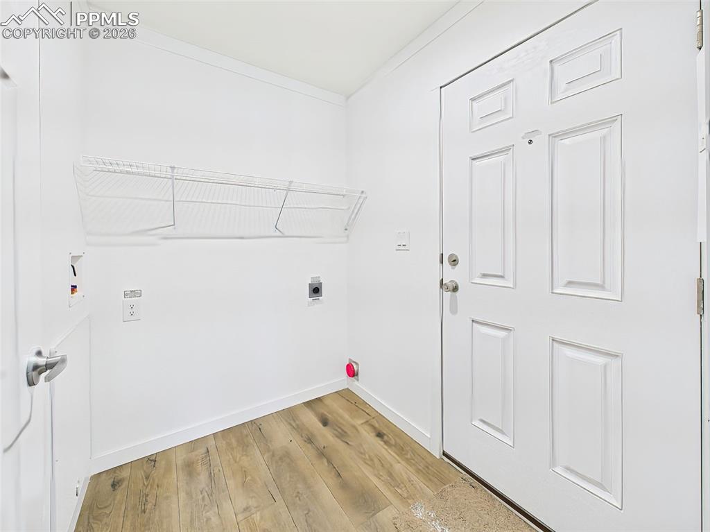 Convenient side entry with washer/dryer hookups, storage shelving, and easy access to the rest of the home.