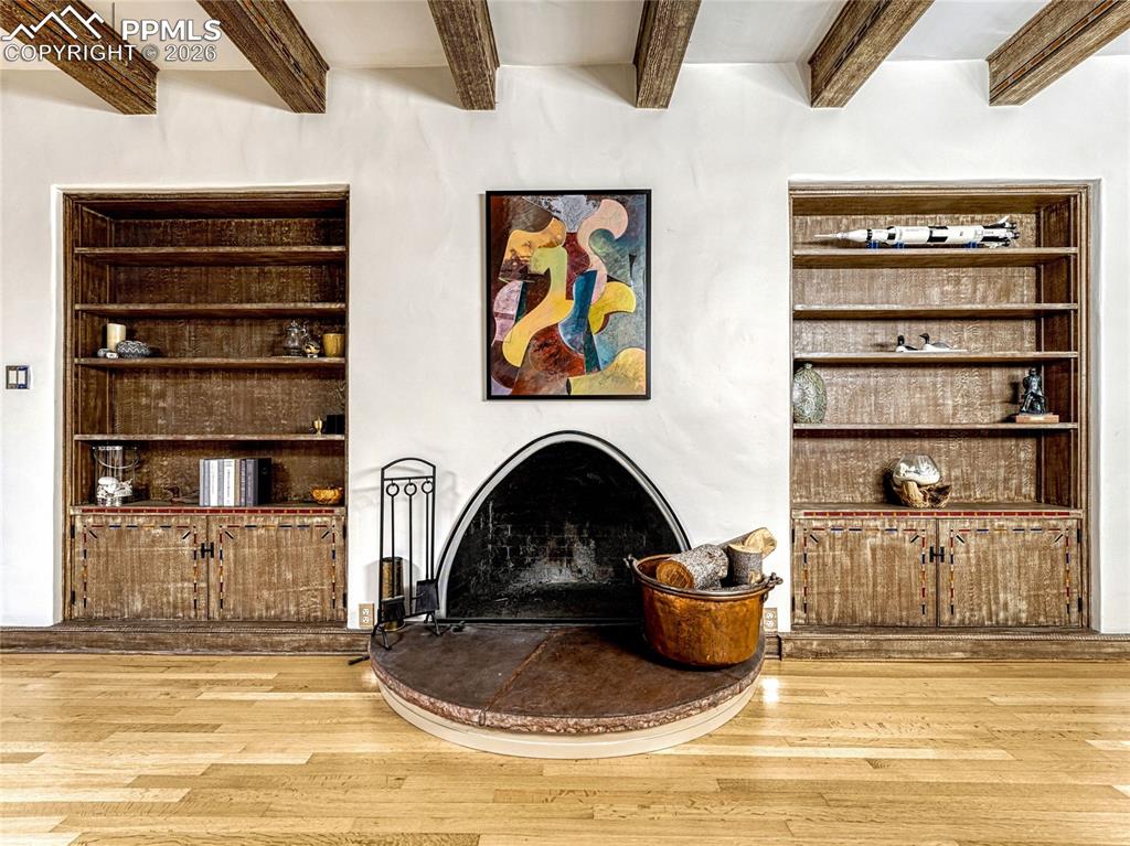 Grand living/dining space has built-in bookcases and a wood-burning fireplace.