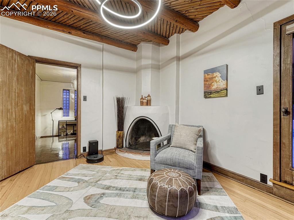 Primary Suite sitting room w/Kiva fireplace & Vigas ceiling.