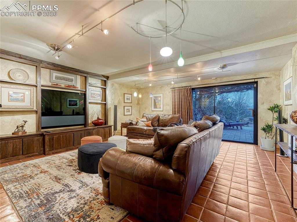 Lower level family room with built-ins, cantina/wet bar and sliding glass door to backyard terrace.