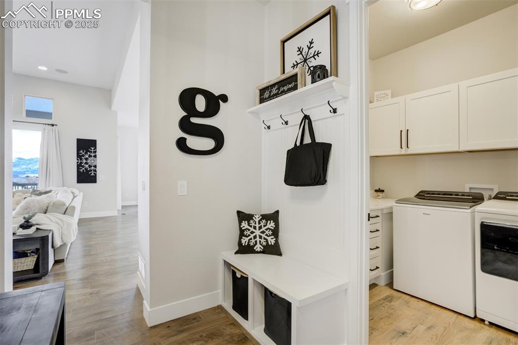 Mudroom adjacent to laundry which features custom cabinetry and a sink