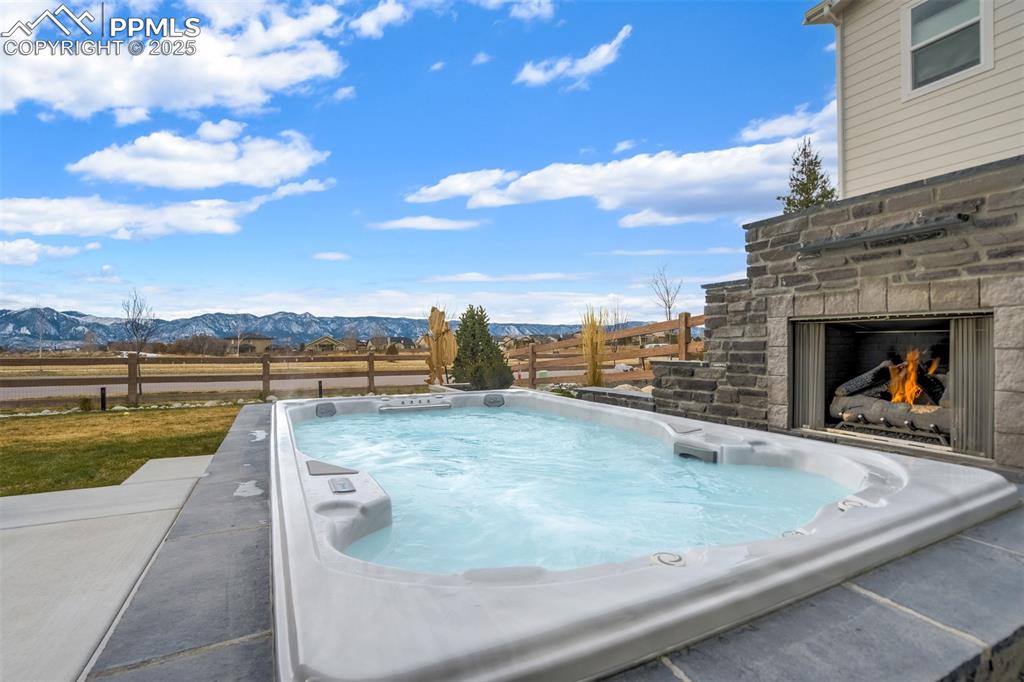 SwimSpa nestled up to 1 of 3 outdoor fireplaces