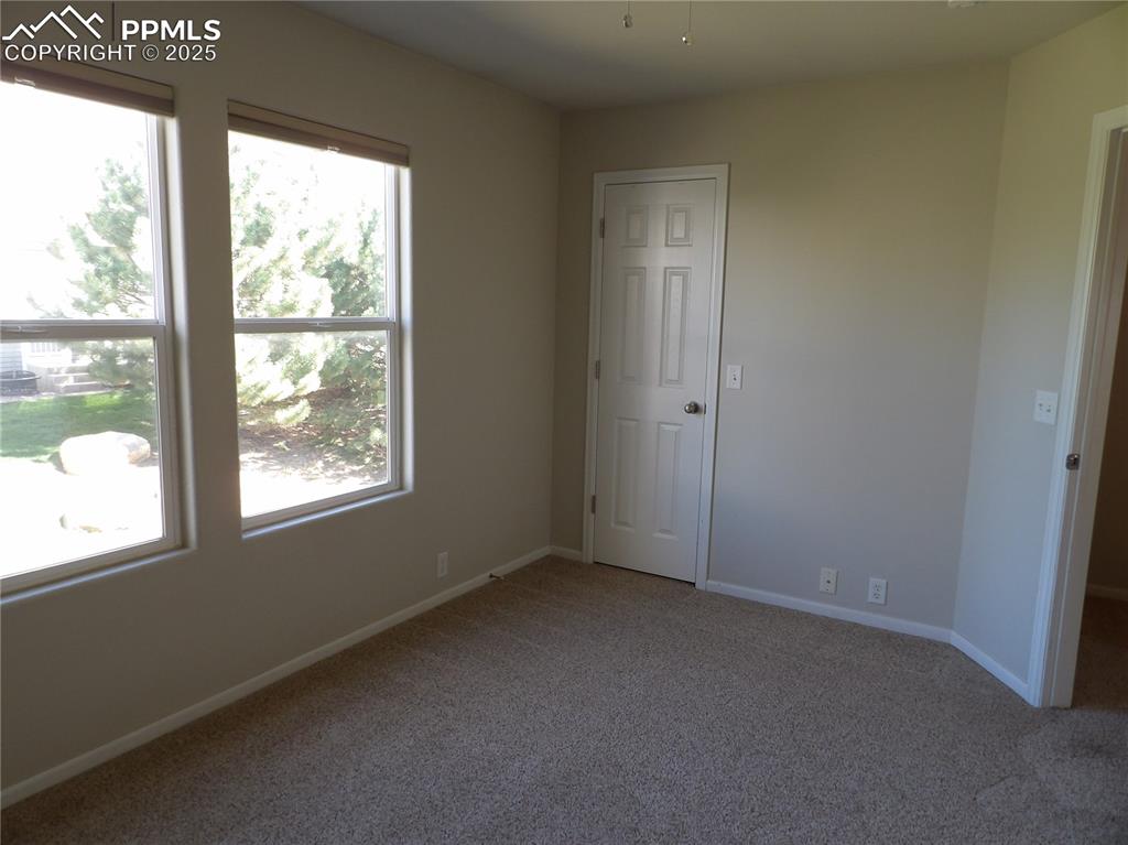 Unfurnished bedroom with carpet floors and baseboards