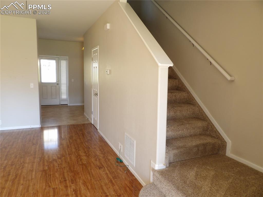 Entryway featuring stairs and wood finished floors