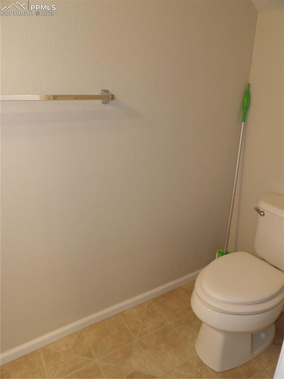 Bathroom with toilet and light tile patterned floors