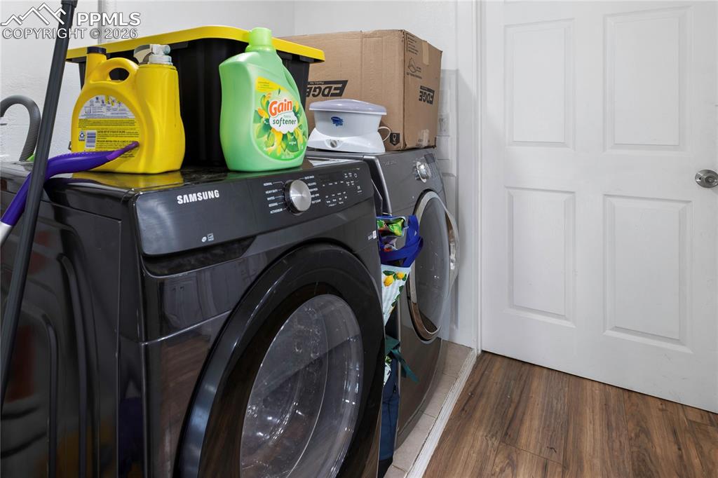 The laundry area with wood finished floors and washer and clothes dryer!