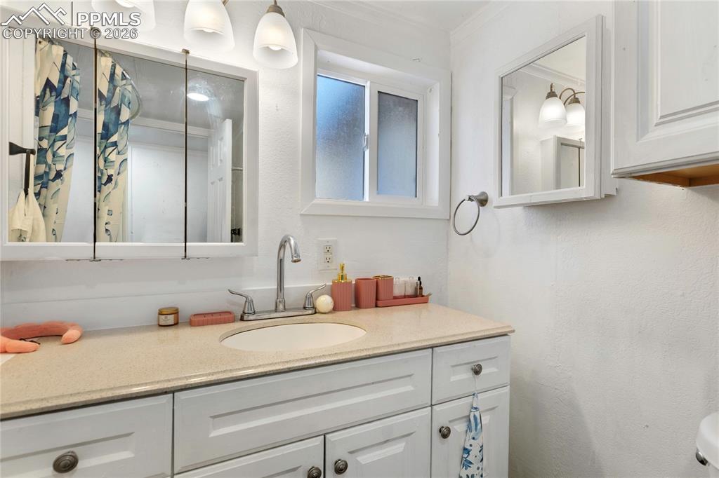 The bathroom featuring vanity and ornamental molding!