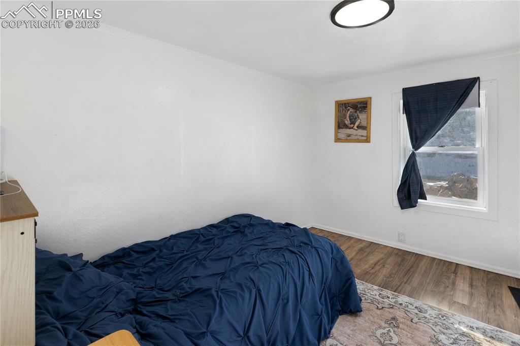 The bedroom featuring wood finished floors and baseboards!