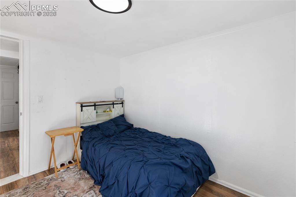 The bedroom with wood finished floors and baseboards!