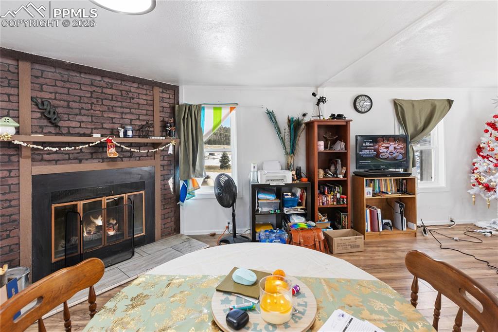 The dining area featuring a fireplace and wood finished floors!