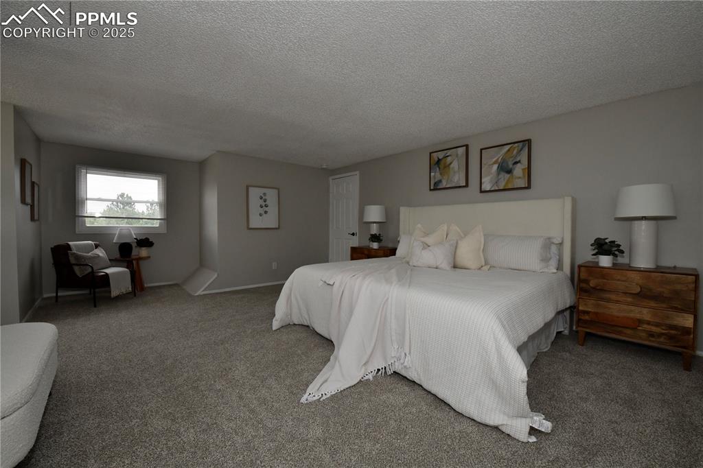 Bedroom with a textured ceiling and carpet floors