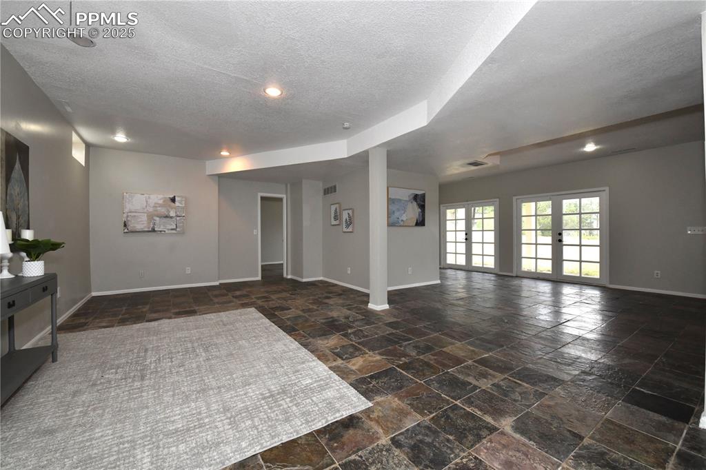 Spare room with stone finish flooring, a textured ceiling, and recessed lighting