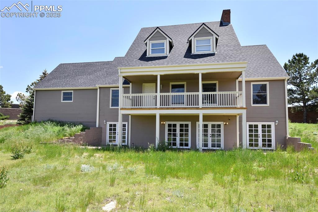 Back of house with french doors, a chimney, roof with shingles, a balcony, and cooling unit