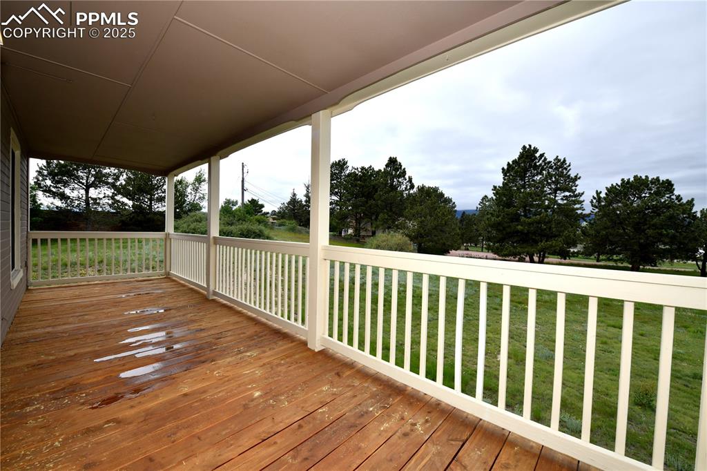 Wooden terrace featuring a yard