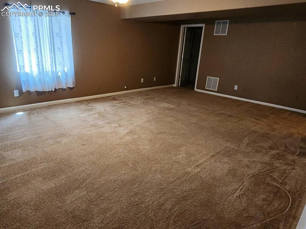 Carpeted empty room with baseboards