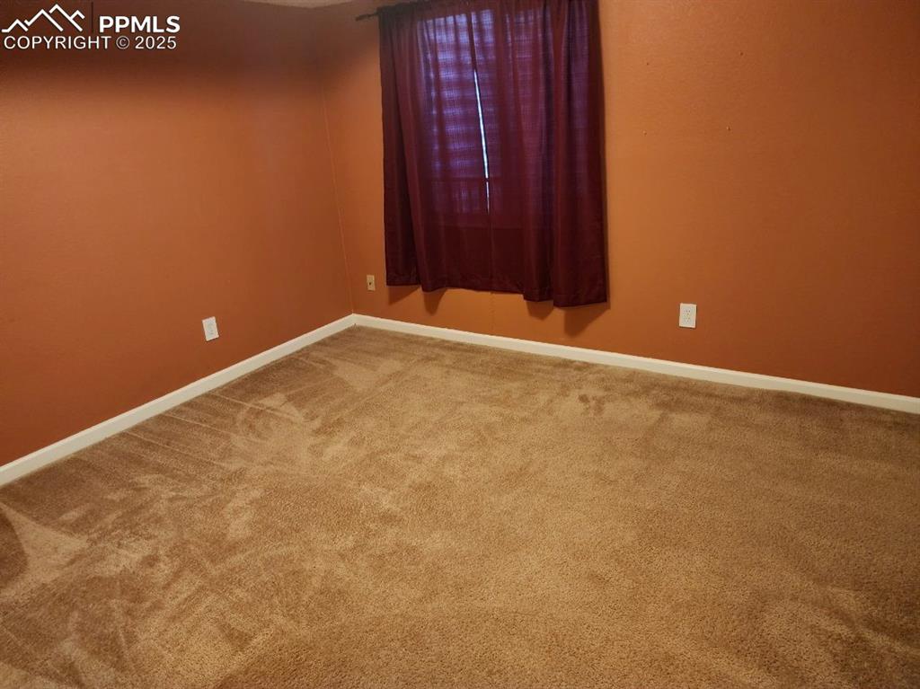 Unfurnished room featuring baseboards and carpet floors