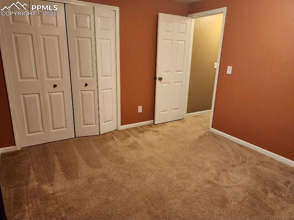Unfurnished bedroom with light colored carpet and a closet