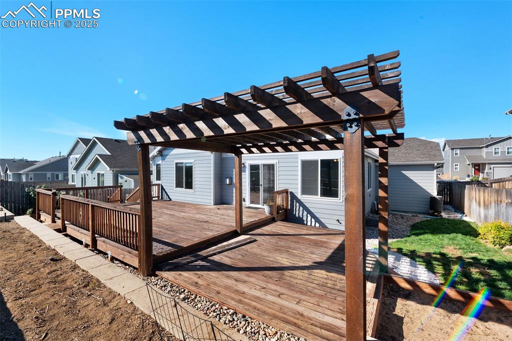 Deck with a pergola and fenced back yard