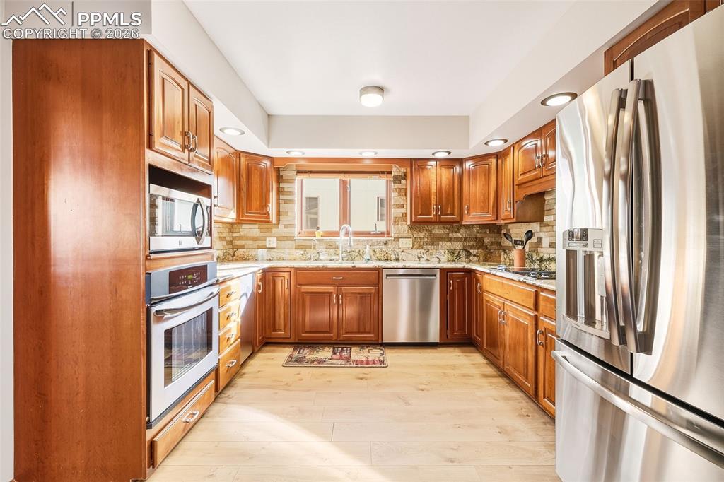 Thoughtfully designed workspace with ample counter space, double sink beneath a window, and direct connection to the dining area for easy entertaining.