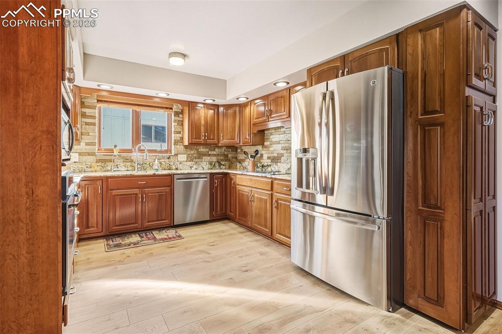 Well-appointed kitchen with stainless steel appliances, abundant cabinetry, and updated flooring. Recessed lighting enhances both functionality and ambiance.