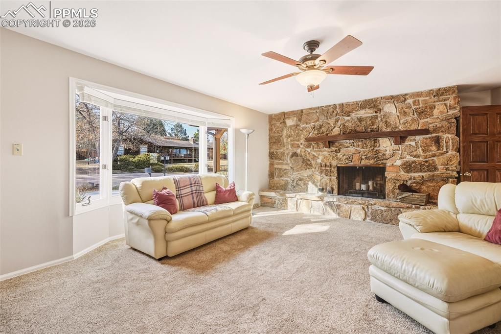 Flexible main-level room with fireplace and large picture window, currently a comfortable living area. Designed to easily function as a bedroom, home office, study, or bonus living space.