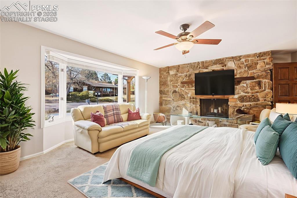 Virtually Staged:  Versatile main-level bedroom highlighted by a warm fireplace, expansive picture window, and ample closet space. Ideal as a guest suite, home office, study, or additional living space with plenty of natural light.
