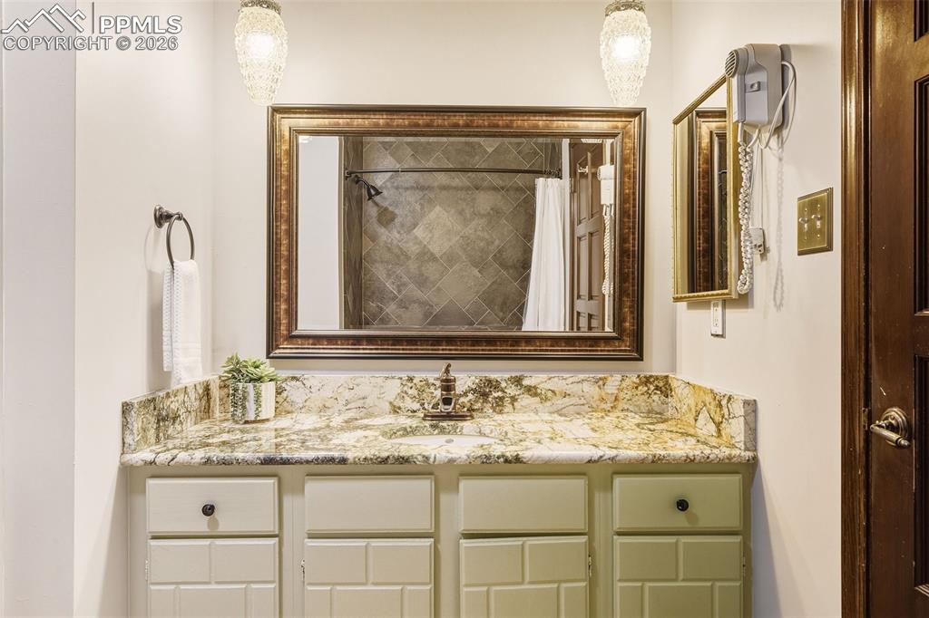 Bathroom #2, Granite countertop, framed mirror, and updated lighting create a polished and cohesive look.