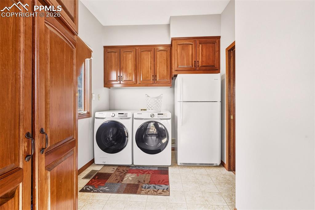Main-level laundry with upper storage cabinetry, additional refrigerator space for convenience with adjoining office area.