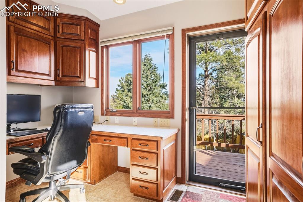 Laundry as a secondary Office / Flex Space – Built-in desk area with upper cabinetry and natural light, offering an ideal space for remote work, hobbies, or organization. Direct access to the deck enhances functionality.
