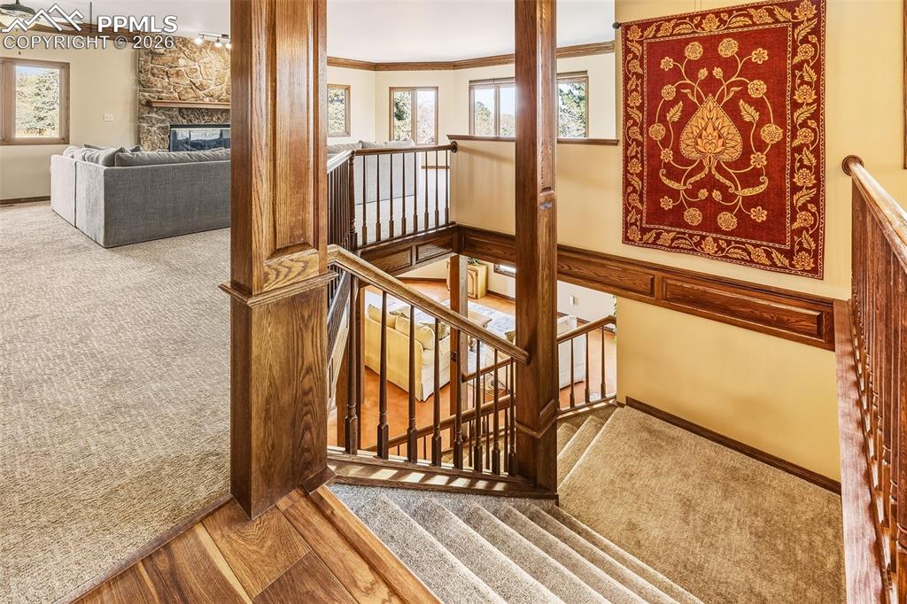 Upper Landing & Staircase – Open stairwell with rich wood trim and railing detail overlooking both levels, creating architectural interest and visual connection throughout the home.