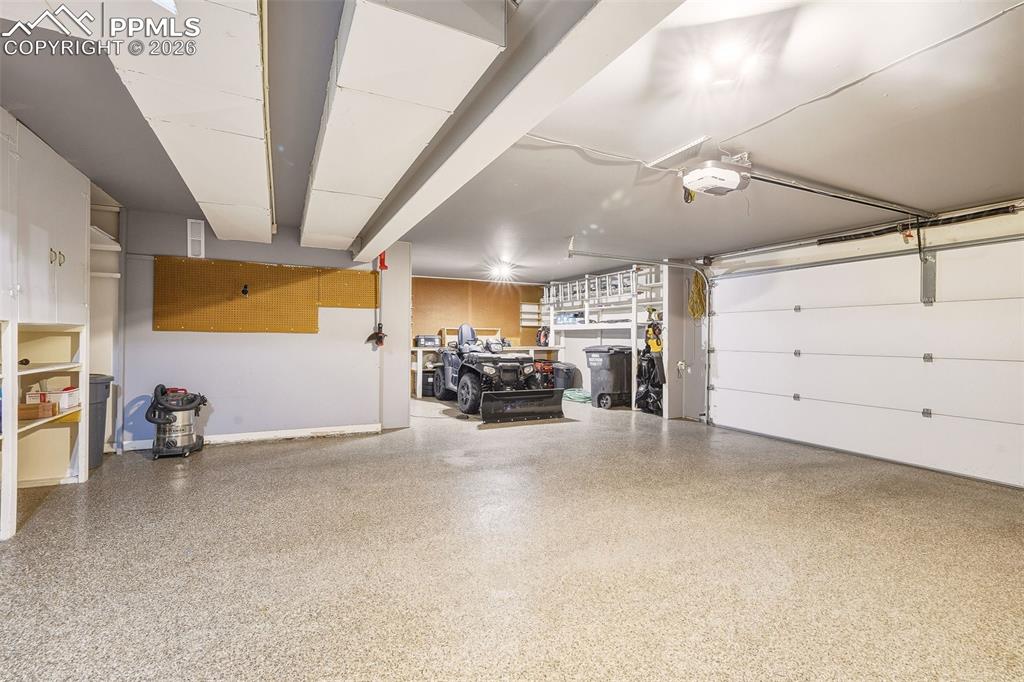 Oversized 2+ car garage with upgraded epoxy-coated flooring, built-in storage, workshop area, Ample space for vehicles, tools, and hobbies.
