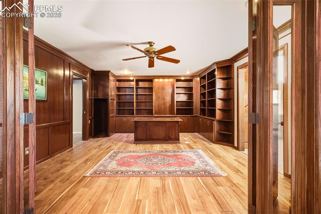 Rich wood detailing and abundant storage define this private workspace, complete with custom cabinetry and display shelving.