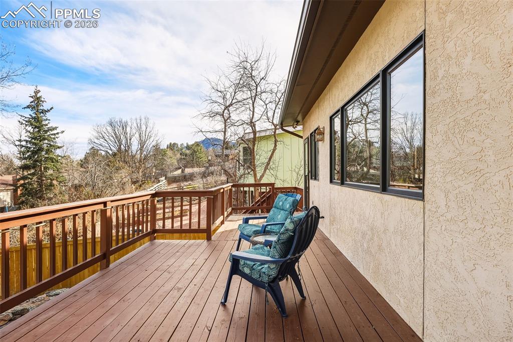 Expansive upper-level deck with replaced and stained deck boards, offering elevated views of the landscaped yard and surrounding trees. A perfect setting for relaxing or entertaining.