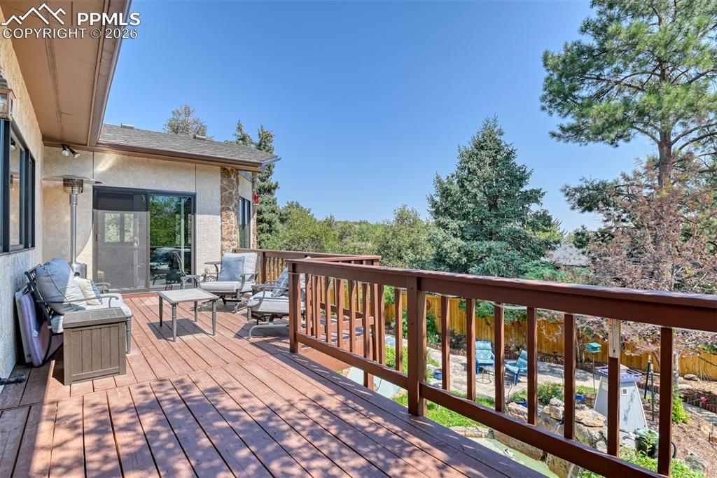 Private outdoor retreat with ample room for seating, treetop views, and seamless access from the main living area through updated sliding glass doors.