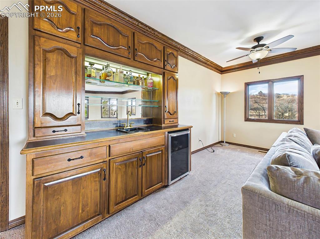 Wet Bar – Custom built-in wet bar with glass shelving, accent lighting, sink, and beverage refrigerator—perfect for hosting guests or creating a cozy evening retreat.