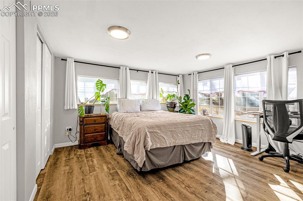 Bedroom with multiple closets and wood finished floors