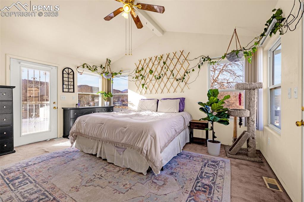 Bedroom featuring carpet floors, access to outside, beam ceiling, and a ceiling fan
