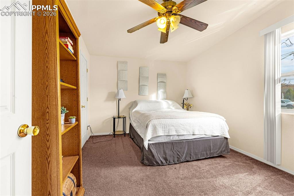 ADU Bedroom 2 with ceiling fan and dark colored carpet