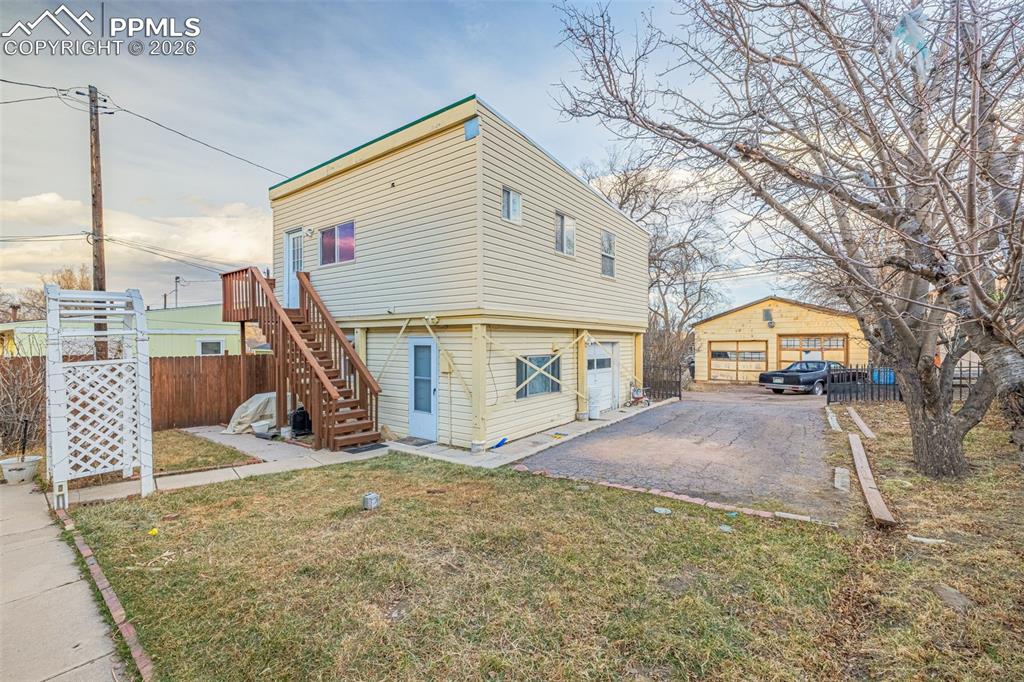 View of ADU property exterior featuring stairway and asphalt driveway